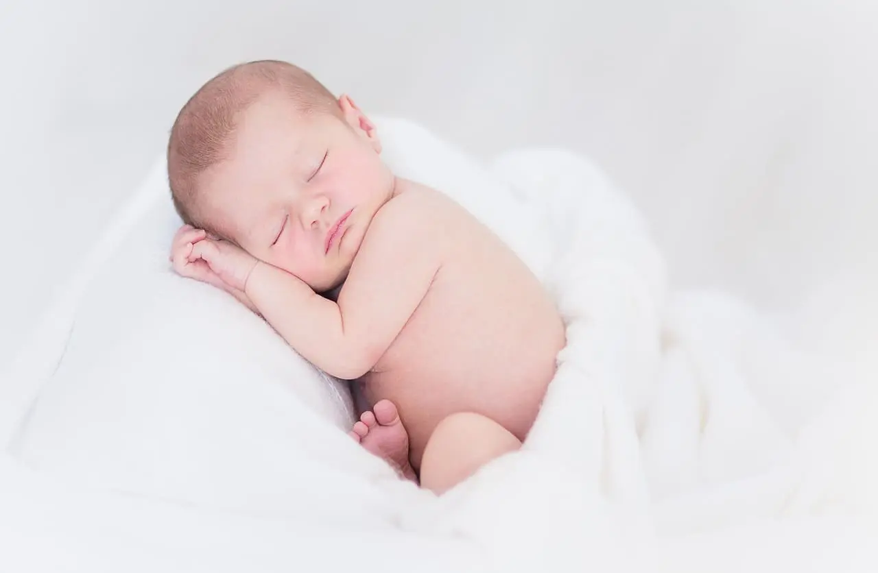 bébé de 1 ou 2 mois dormant dans une couverture blanche